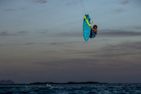 Duotone Volt D/LAB kite surfboard en train de faire du kitesurf sur l'océan avec des îles au loin