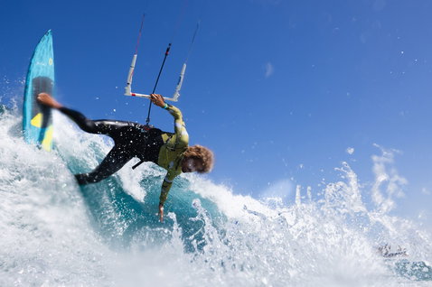 Duotone Volt D/LAB kite surfboard lors du surf de vagues sur la plage océanique