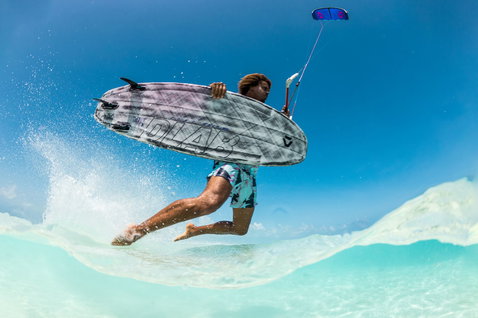 Duotone Whip D/LAB kite surfboard during kitesurfing at a tropical ocean beach