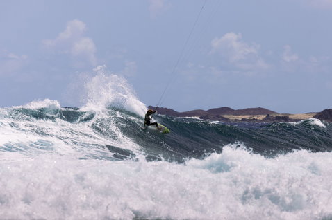 Duotone Blur D/LAB kiteboard de vagues pendant le kitesurf sur l'océan avec littoral rocheux