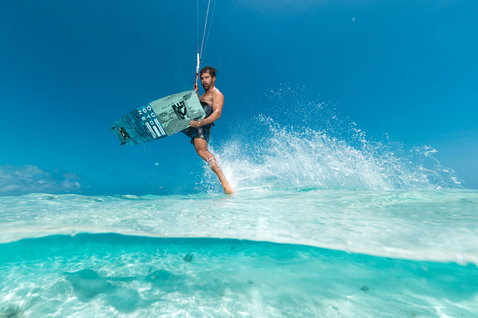 Duotone Select SLS twin-tip kiteboard during kitesurfing in shallow turquoise water in a tropical ocean