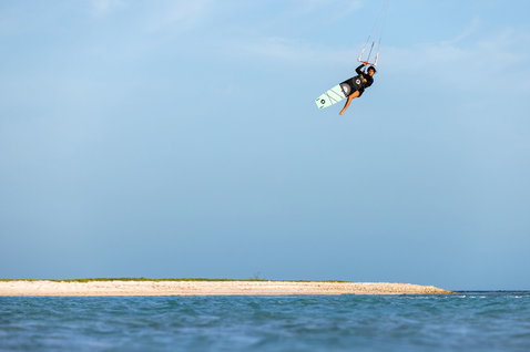 Duotone Soleil SLS twin-tip kiteboard during kitesurfing at a tropical ocean beach with sandbar