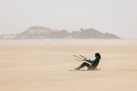 Duotone Shred kiteboard twin-tip pendant le kitesurf sur une plage de sable désertique