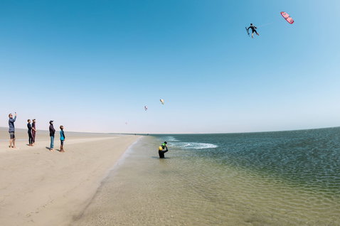 Duotone Shred twin-tip kiteboard en train de faire du kitesurf sur une plage de sable avec lagon