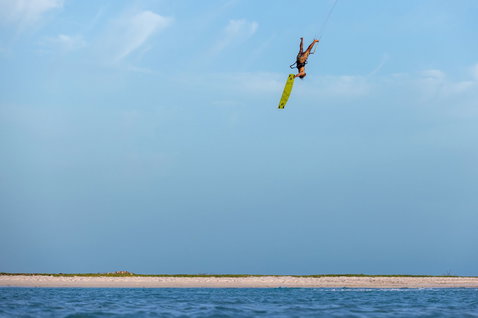 Duotone TS Big Air SLS twin-tip kiteboard during kitesurfing at an ocean beach