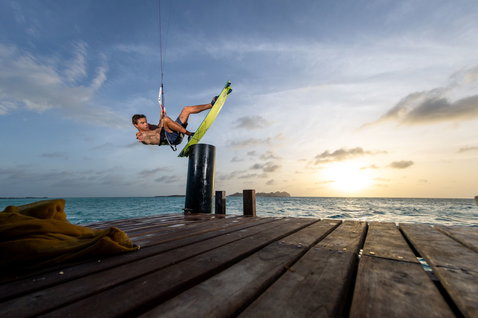 Duotone TS Big Air SLS twin-tip kiteboard during kitesurfing at a tropical ocean pier