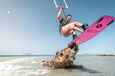 Duotone Boot Team Series wake-style kiteboard during wakestyle kiteboarding on the beach in shallow water, Sicily