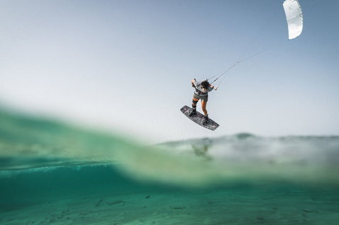 Kiteboard twin-tip Duotone TS Freestyle SLS durante il kitesurf in un oceano tropicale poco profondo