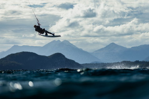 Duotone TS Park planche twin-tip de kitesurf lors du kitesurf sur un lac avec panorama montagneux