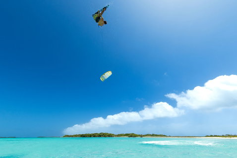 Duotone Entity Ergo D/LAB kiteboard twin-tip en kitesurf sur une plage tropicale
