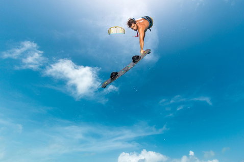 Duotone Entity Ergo twin-tip kiteboard en train de faire du kitesurf au-dessus de l'océan