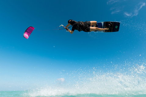 Duotone Entity SLS kiteboard twin-tip lors d'une session de kitesurf sur la plage de l'océan