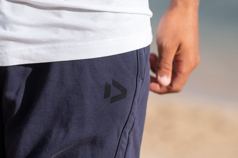 Duotone Shorts Sweat True Fade Out long unisex sweat shorts in dark navy, detail view at ocean beach