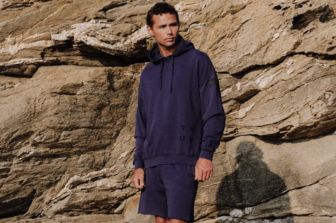 Duotone Shorts Sweat True Fade Out long unisex worn at a rocky coastline in navy blue