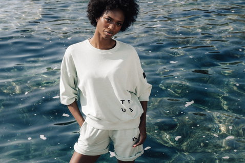 Duotone Apparel Shorts Sweat True Fade Out Long unisex sweat shorts during a standing pose at a shallow water shoreline