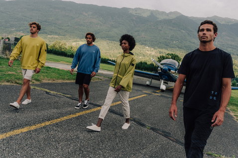 Duotone Apparel Explore unisex pantalón de viaje de pie en un aeródromo con paisaje montañoso