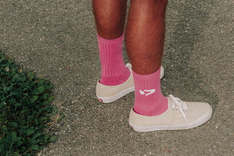 Chaussettes Duotone Originals en rose vif portées avec des sneakers en extérieur