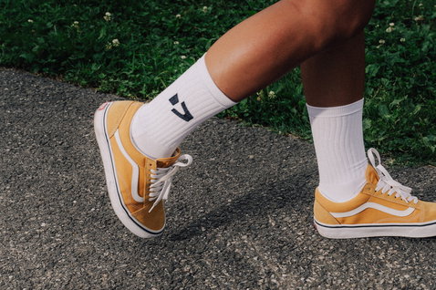 Chaussettes Duotone Originals en blanc avec logo tricoté portées dans un contexte lifestyle urbain