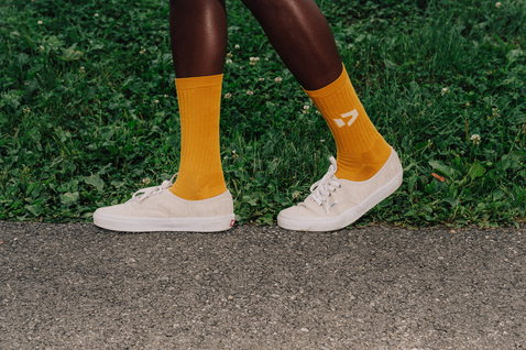 Chaussettes Duotone Originals en jaune doré portées avec des baskets en extérieur