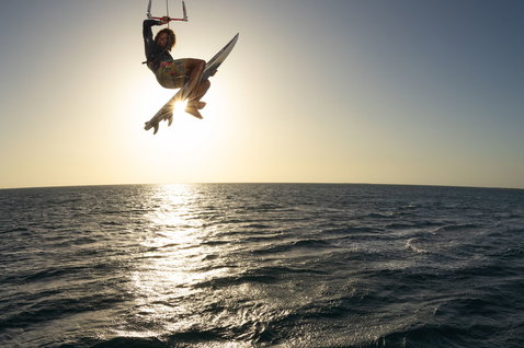Prancha de kitesurf Duotone Whip SLS Concept Blue durante manobra aérea strapless freestyle no oceano aberto