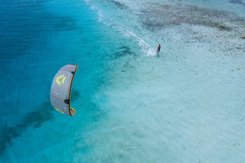 Duotone Volt SLS Concept Blue kite surfboard en kitesurf dans un lagon tropical peu profond avec récif