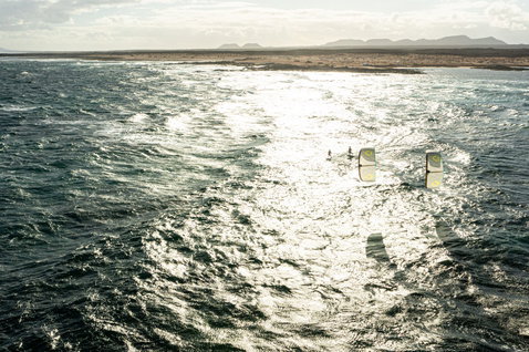 Duotone Volt SLS Concept Blue wave kiteboard en kitesurf dans l'océan ouvert avec littoral aride en arrière-plan