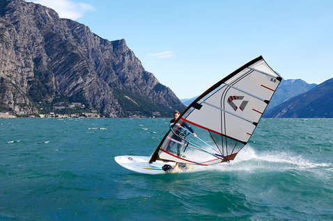 Duotone Blast D/LAB planche de windsurf lors de windsurf sur un lac alpin avec toile de fond montagneuse