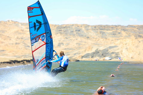 Duotone Falcon Speed D/LAB windsurf board lors du windsurf sur un parcours de vitesse en eaux plates dans un lagon côtier aride