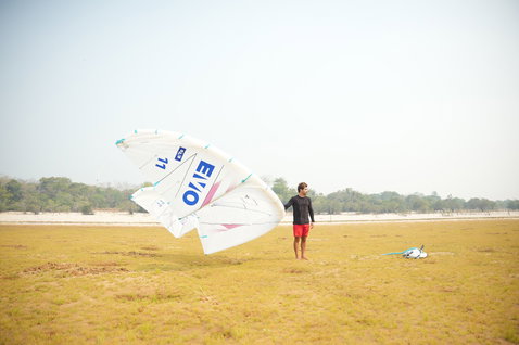 Duotone Evo SLS LEI Kite beim Kitesurfen auf flachem Sandstrand mit Graslandschaft
