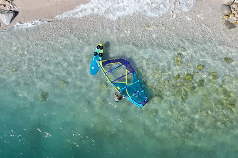 Duotone Eagle SLS planche de windsurf lors de windsurf sur une rive rocheuse aux eaux claires et peu profondes