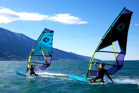 Duotone E_Pace 2025 freeride sail during windsurfing on an alpine lake with mountain backdrop