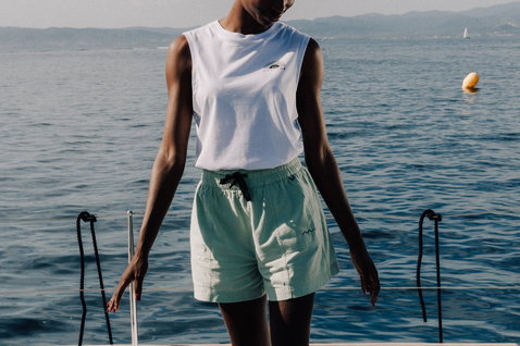 Duotone Apparel Shorts True femme short de plage en pose debout sur le ponton au bord de l'océan