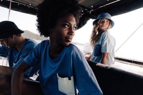 T-shirt en bleu moyen lors d'un lifestyle plage sur le pont d'un bateau avec océan et collines en arrière-plan