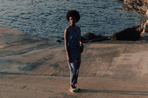 Tuta Duotone Jumpsuit True Women indossata su un molo roccioso costiero vicino all'oceano