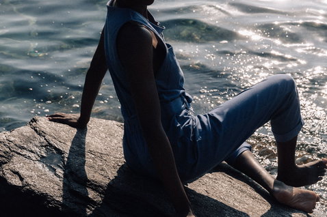 Duotone Apparel Jumpsuit True women durante lifestyle in spiaggia su una costa rocciosa