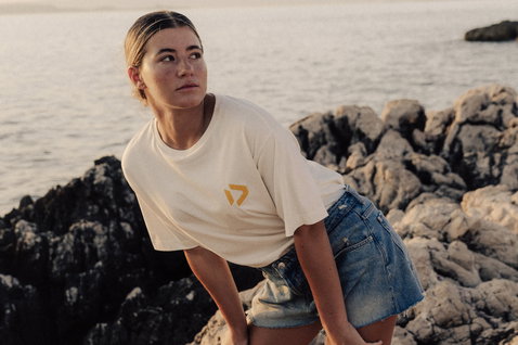 Duotone Apparel Tee SS CB Concept Blue women's t-shirt at a rocky coastline by the ocean
