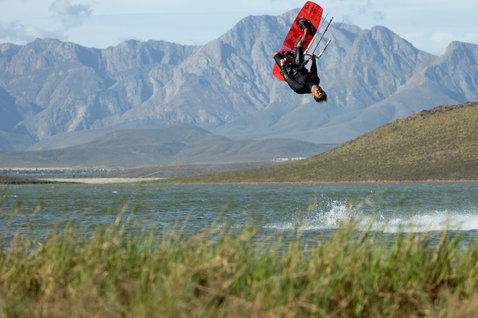 Duotone Gonzales twin-tip kiteboard lors d'une session de kitesurf sur un lac plat avec montagnes