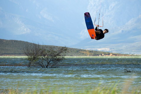Duotone Gonzales kiteboard twin-tip lors d'une session de kitesurf sur un lagon intérieur avec montagnes