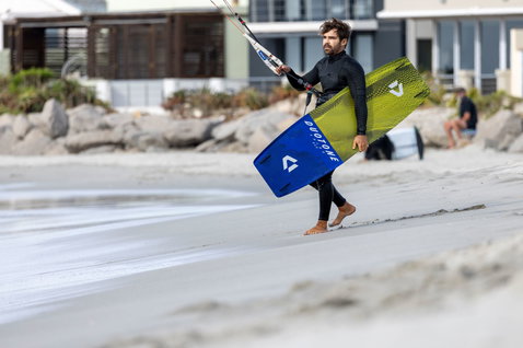 Duotone Spike SLS twin-tip kiteboard during kitesurfing at an ocean beach