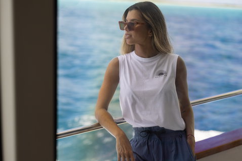 Duotone Apparel Tank True women sleeveless tank top in white posing on a yacht deck at sea