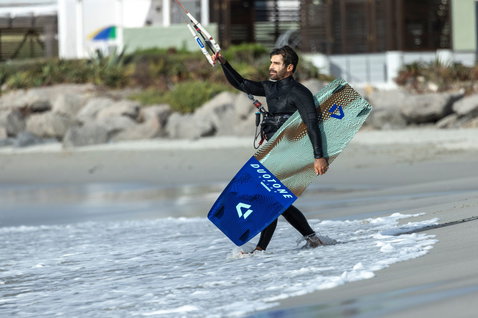 Duotone Spike Concept Blue twin-tip kiteboard during kitesurfing on an ocean beach