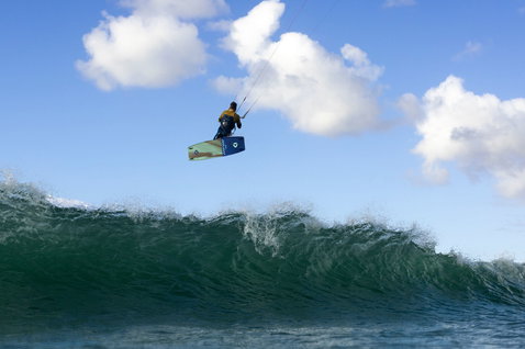 Duotone Spike CB twin-tip kiteboard during kitesurfing on the ocean with breaking waves