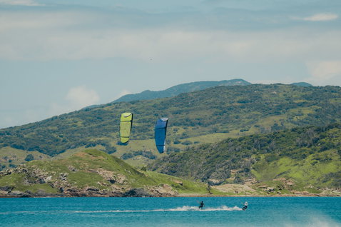 Duotone Juice LEI Kite beim Kitesurfen in einer Küstenlagune mit grünen Hügeln