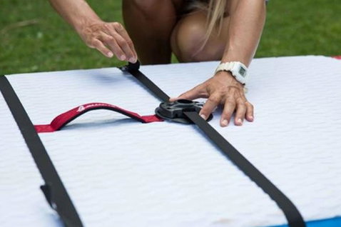 Duotone Adapter Strap for Base Plate accessory during rigging on an outdoor grass area