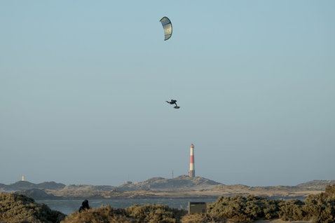 Duotone D/LAB LEI kite en kitesurf sur une plage côtière avec dunes et phare