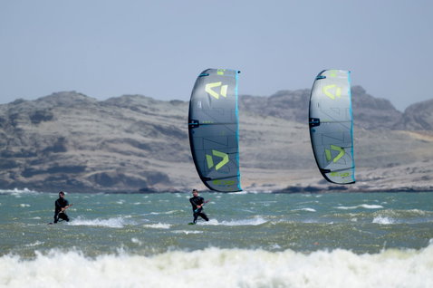 Duotone D/LAB LEI kite en action lors d'une session de kitesurf en mer avec montagnes rocheuses