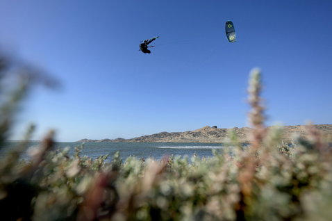 Duotone D/LAB LEI kite en action lors d'une session de kitesurf dans un lagon côtier avec dunes