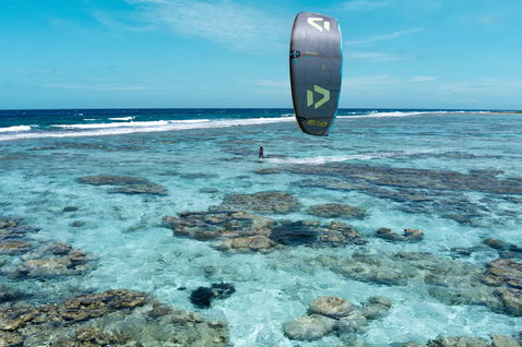 Duotone Evo D/LAB LEI kite durante il kitesurf in una laguna di barriera corallina tropicale