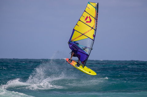 Duotone Ultra FreeWave D/LAB windsurf board during wave riding at an ocean beach