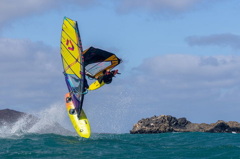 Duotone Ultra FreeWave D/LAB Customized windsurf board during wave riding at the ocean with rocky coastline